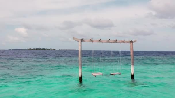 Gimbal shot of swing in Maladewa clear ocean, waves and panoramic view — Stok Video