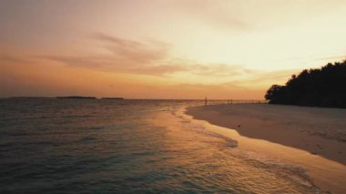 Gimbal, Maldivler 'in okyanus ve ada üzerinde gün doğumunu, panoramik turuncu gökyüzünü görüntüledi.