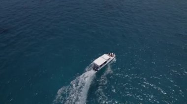 Beyaz teknenin insansız hava aracı görüntüleri Maldivler 'de Hint Okyanusu' nda dalgalar ve köpüklerle yüzüyor.