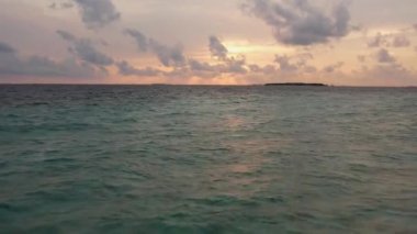 Drone view of Maldives sunset over ocean, panoramic sky with island
