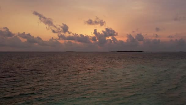 Gimbal tilt down of Maldives sunset and swing in ocean, panoramic sky and island – stockvideo