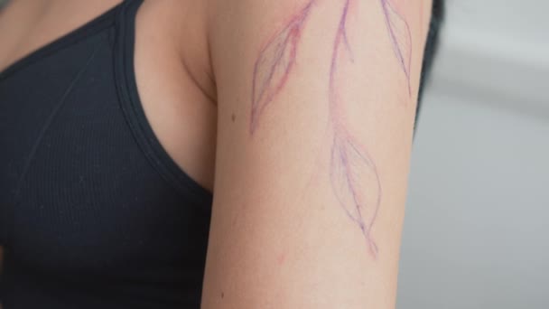 Una tecnica del tatuaggio a mano libera viene disegnata sulla mano dei clienti, schizzo direttamente sulla pelle con marcatori invece di trasferire uno stencil, in tempo reale — Video Stock