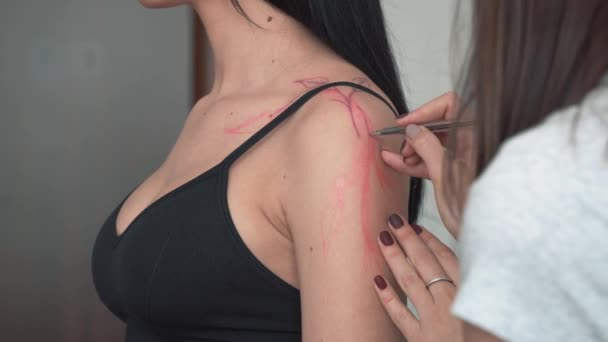 На руці клієнтів малюється техніка вільного татуювання, ескіз безпосередньо на шкірі з маркерами замість перенесення трафарету, в режимі реального часу — стокове відео