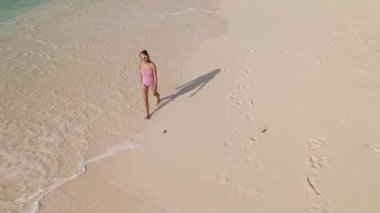 Yüzmeye, okyanusa ve sahile giden mayo giymiş bir kadının robot resmi.
