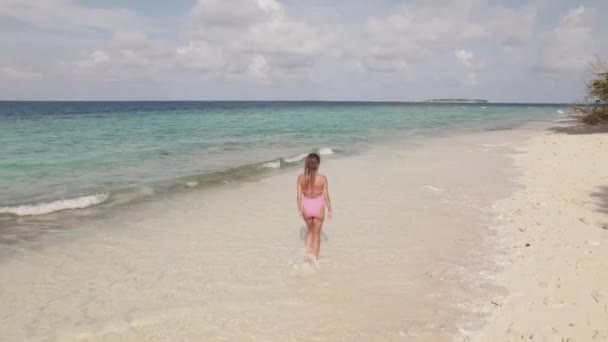 Mujer caminando en una playa en tiempo soleado, olas del océano y horizonte — Vídeos de Stock