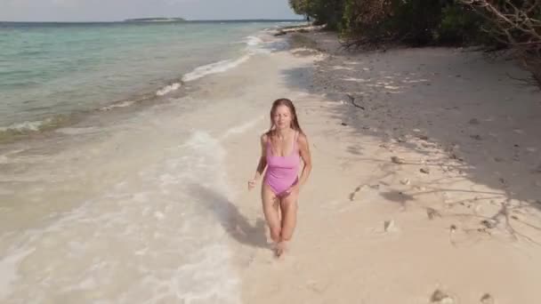 Mujer corriendo en la costa de la playa de Maldivas, olas y árboles — Vídeos de Stock