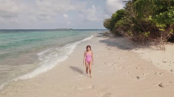 Mujer caminando en una costa de playa, Maldivas olas y árboles — Vídeos de Stock
