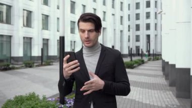 Yakışıklı iş adamı yönetici patron iş ortağıyla telefonda konuşuyor. Video konferans çağrısı kavramı