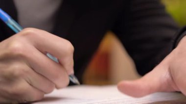 İş adamı not alıyor ya da kontrat imzalıyor, kalem ve belge, resmi ceketli adam. Elini kapat..