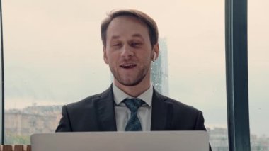 İş adamı bir video konferansında konuşuyor, çevrimiçi iletişim, çalışma süreci, dışarıda yağmurlu ve bulutlu.