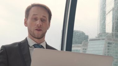 İş adamı bir video konferansında konuşuyor, çevrimiçi iletişim, çalışma süreci, dışarıda yağmurlu ve bulutlu.