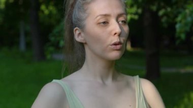 Genç ve formda bir kadın sabah vakti parkta yoga yapıyor. Güzel kız dışarıda yoga egzersizi yapıyor. Gerçek zamanlı.