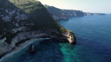 Kayalık uçurumun havadan görüntüsü. Hint Okyanusu kıyısında. Güzel doğa ve yaz tatili konsepti. İnsansız hava aracı gün batımında kıyı şeridi boyunca uçar. Bali 'deki Nusa Penida Adası