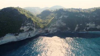 Kayalık uçurumun havadan görüntüsü. Hint Okyanusu kıyısında. Güzel doğa ve yaz tatili konsepti. İnsansız hava aracı sağdan sola uçuyor. Bali 'deki Nusa Penida Adası