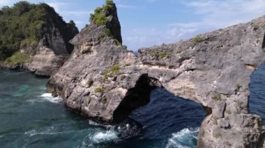 Kayalık uçurumun havadan görüntüsü. Hint Okyanusu kıyısında. Güzel doğa ve yaz tatili konsepti. Drone adaya yaklaşıyor. Bali 'deki Nusa Penida Adası