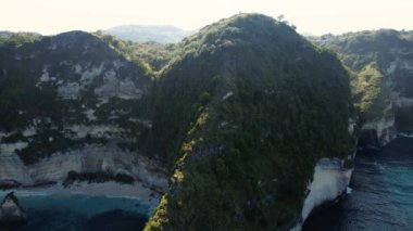 Kayalık uçurumun havadan görüntüsü. Hint Okyanusu kıyısında. Güzel doğa ve yaz tatili konsepti. İnsansız hava aracı soldan sağa uçuyor. Bali 'deki Nusa Penida Adası