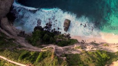 Kumsalın, Hint okyanus dalgalarının ve palmiyelerin havadan çekilmiş görüntüsü. Güzel doğa ve yaz tatili konsepti. Drone yükseliyor. Bali 'deki Nusa Penida Adası