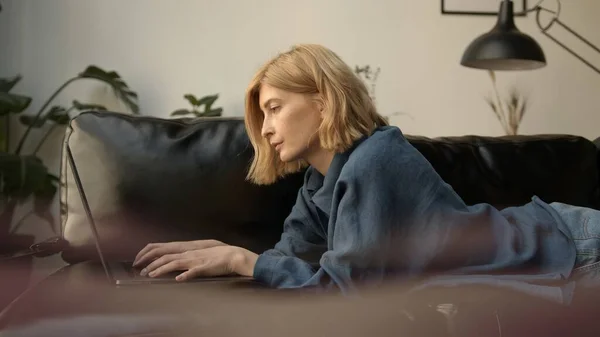 Genç Bir Kadın Dizüstü Bilgisayar Kullanıyor Oturma Odasında Kanepede Dinleniyor — Stok fotoğraf