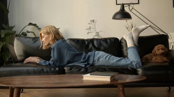 Genç Bir Kadın Dizüstü Bilgisayar Kullanıyor Oturma Odasında Kanepede Dinleniyor — Stok fotoğraf
