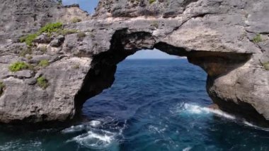 Kayalık uçurumun havadan görüntüsü. Hint Okyanusu kıyısında. Güzel doğa ve yaz tatili konsepti. İnsansız hava aracı Bali 'deki Nusa Penida Adası' nda geriye doğru uçuyor.