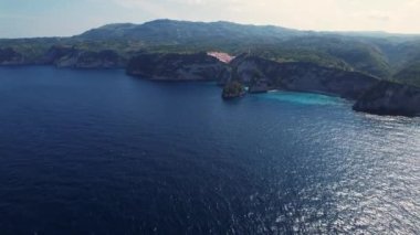 Kayalık uçurumun havadan görüntüsü. Hint Okyanusu kıyısında. Güzel doğa ve yaz tatili konsepti. İnsansız hava aracı gün batımında kıyıya doğru uçar. Bali 'deki Nusa Penida Adası