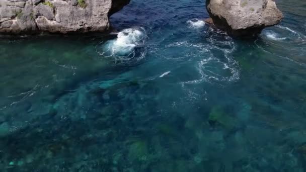岩石拱形悬崖的空中拍摄 印度洋海岸 美丽的自然和旅行暑假的概念 巴厘岛努沙佩尼达岛 无人机向后飞去 — 图库视频影像