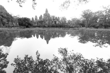 Angkor Thom, Siem Reap, Kamboçya 'da yansımalı Bayon' un geniş açılı siyah beyaz görüntüsü.