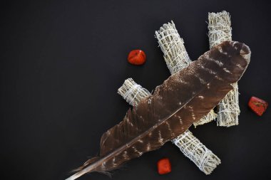 Siyah arka planda kutsal tüyü olan üç beyaz adaçayının en üst görüntüsü.. 
