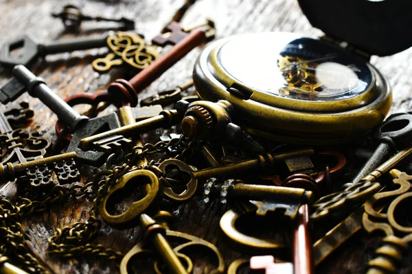 Altın renkli cep saati olan birkaç eski anahtarın düşük açılı görüntüsü.. 