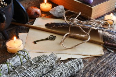 Sihirli değnek, kutsal tüy ve büyü kitabıyla beyaz adaçayı lekelerinin düşük açılı görüntüsü..