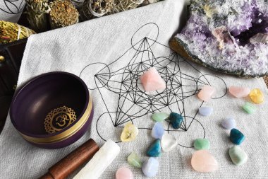 Şifalı kristaller ve mor bir meditasyon kasesi olan kutsal bir geometri şebekesinin üst görüntüsü.. 