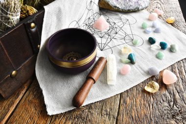 Şifalı kristaller ve mor bir meditasyon kasesi olan kutsal bir geometri şebekesinin üst görüntüsü.. 
