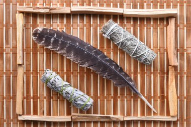 Hasır arka planda iki beyaz adaçayı lekesi ve kutsal tüy görüntüsü.. 