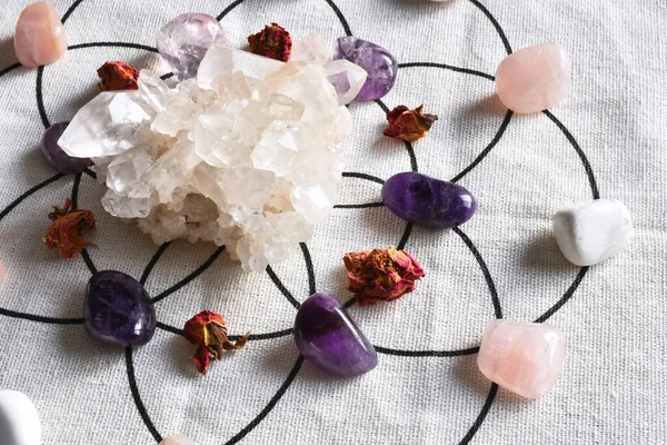 A close up image of a crystal healing grid with clear quartz cluster and amethyst.