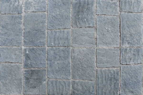 An abstract image of grey concrete patio tiles.