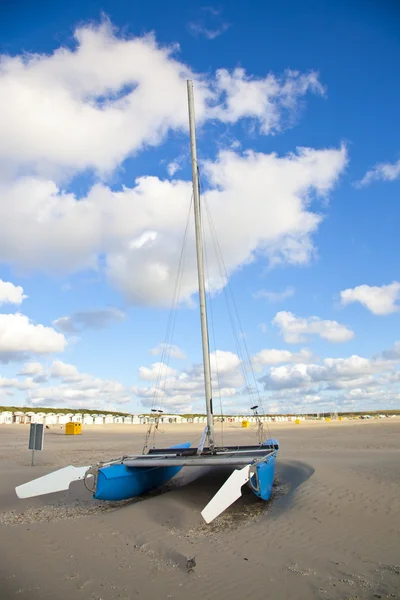 Barca catamarano blu sulla spiaggia con cielo blu — Foto Stock