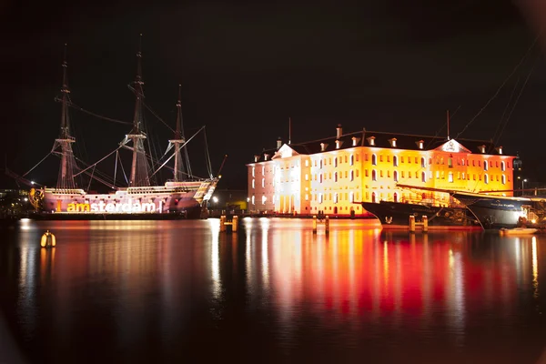 AMSTERDAM, THE NETHERLANDS: Building and ancient ship with lights at the annual Amsterdam Light Festival on December 30, 2013. Amsterdam Light Festival - фестиваль зимнего света — стоковое фото