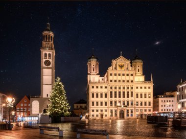 Geceleyin Augsburg 'daki tarihi kasaba meydanında aydınlatılmış Noel ağacı.