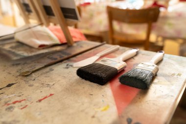 Two Paint brushes and painters knife lying ready for use on an artist table in an atelier