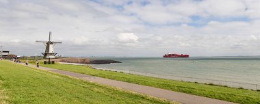 Hollanda 'nın Vlissingen yakınlarındaki hendekte bulunan geleneksel yel değirmeni Oranjemolen Hollanda' nın denize yakın olan tek yel değirmeni. bölge Zeeland