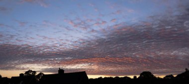 Gökyüzü sirokümülüs bulutlarıyla bembeyaz ve gri ve yazın açık mavi bir gökyüzü