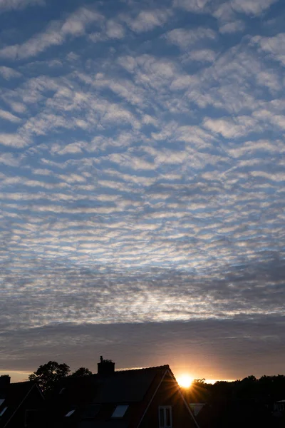 Gökyüzü sirokümülüs bulutlarıyla bembeyaz ve gri ve yazın açık mavi bir gökyüzü