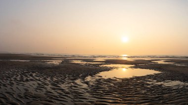 Fransız Opal Sahili sahilinde deniz ve yapıları olan kumlu bir günbatımı. Uzayı kopyala Ufuk