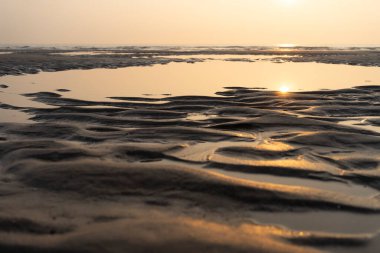 Fransız Opal Sahili sahilinde deniz ve yapıları olan kumlu bir günbatımı. Uzayı kopyala Ufuk