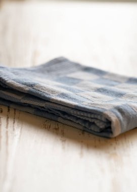 Beyaz ahşap masadaki mavi kareli masa örtüsü kopya alanı ve yumuşak ışıkta sığ alan derinliği