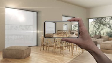 El ele tutuşan akıllı telefon, AR uygulaması, gerçek evde mobilya ve iç tasarım ürünleri simülasyonu, mimar tasarım konsepti, bulanık arka plan, modern yemek odası ve oturma odası