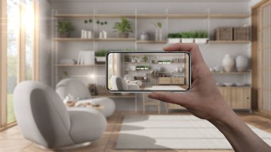 El ele tutuşan akıllı telefon, AR uygulaması, gerçek evde mobilya ve iç tasarım ürünleri simülasyonu, mimar tasarım konsepti, bulanık arka plan, koltuklu modern oturma odası