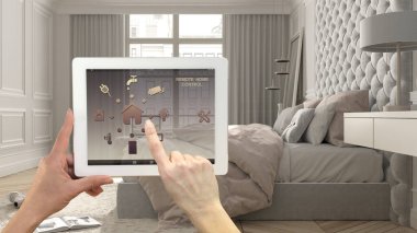 Dijital tablette akıllı uzaktan kumanda sistemi. Uygulama simgeleri olan aygıt. Pastel klasik parlak yatak odası, arka planda panoramik pencere, mimari iç tasarım.