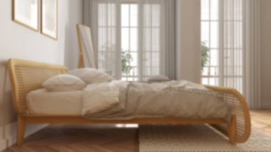 Bulanık arka plan, minimalist İskandinav ahşap yatak odası, rattan mobilyalı, yorgan ve yastıklı çift yatak, parke, pencere, halı ve ayna. Modern iç tasarım