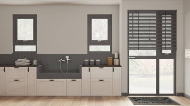 Evcil hayvanlara ayrılmış bir yer, karanlık tonlarda modern çamaşırhane dolapları ve mozaik fayanslar ve musluklarla köpek banyosu. Parke zemin ve pencereler. Konforlu iç dizayn konsepti